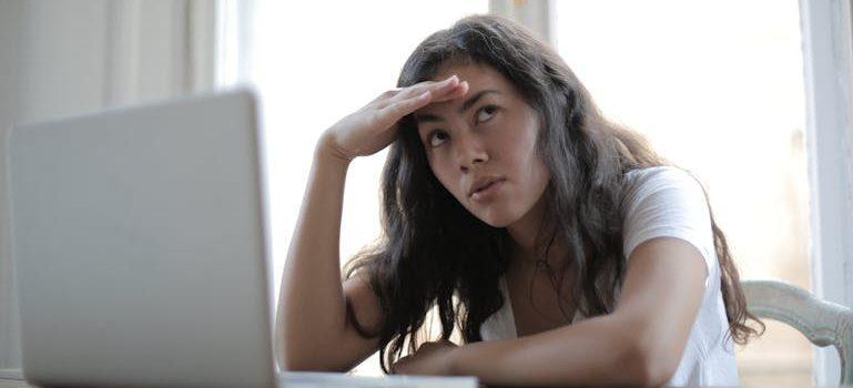 an annoyed young woman using her laptop